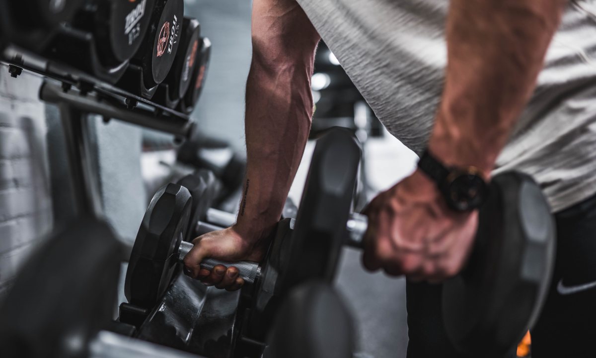 A man picking up a set of dumbbells