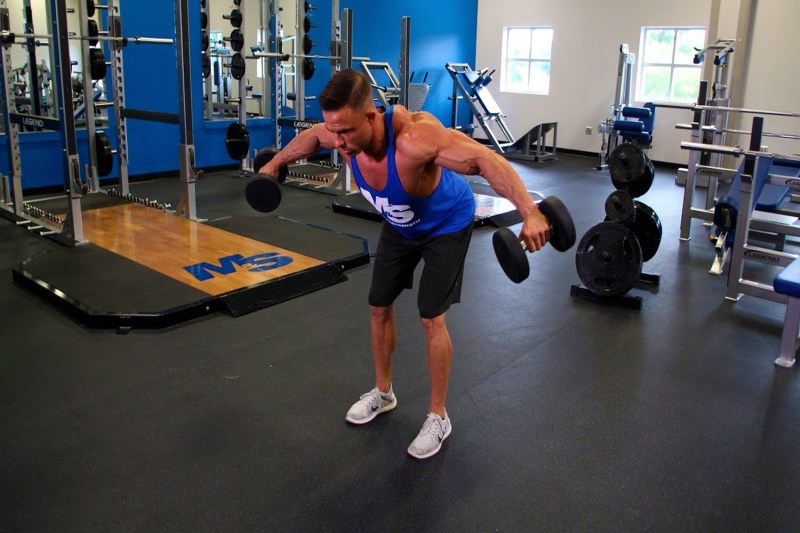 Man trying out a Bent-Over Reverse Fly with a dumbbell in each hand.