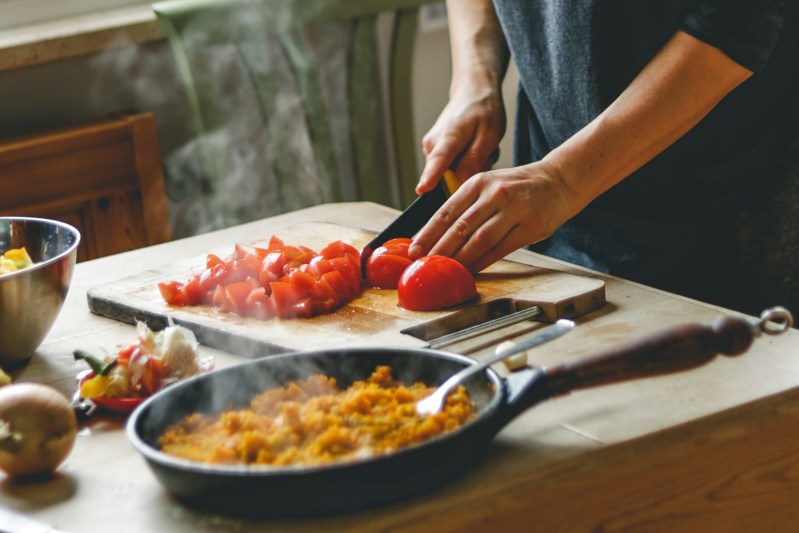 A person cutting up tomatoes for a healthy meal