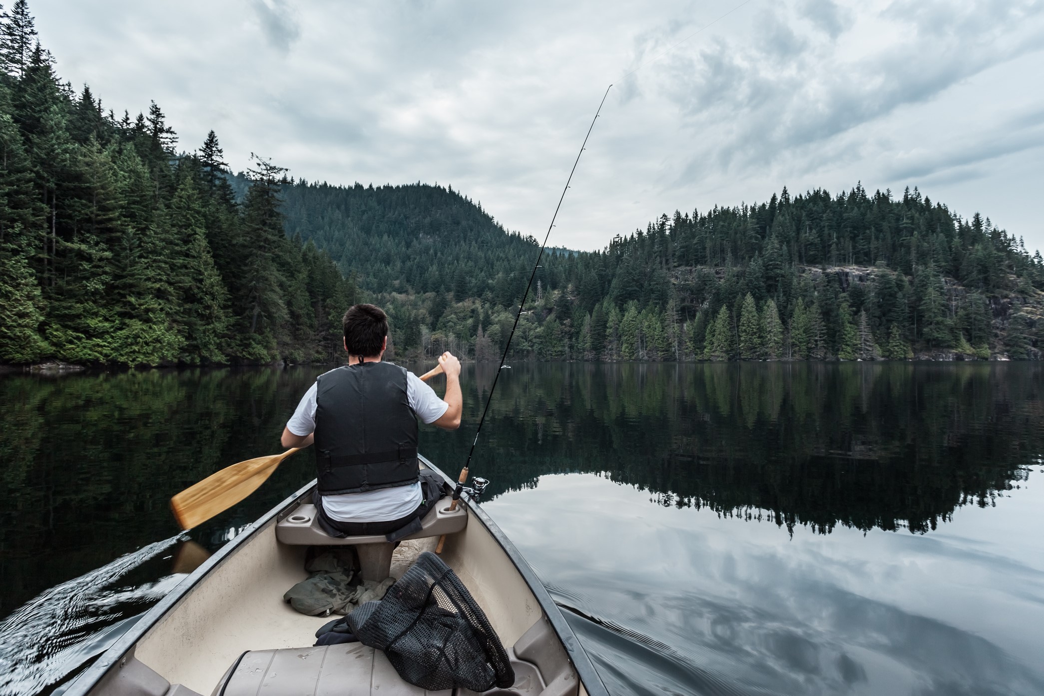 Person fishing from a canoe at Buntzen Lake in British Columbia, Canada.