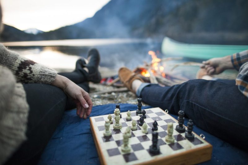 Campers playing chess outdoors.