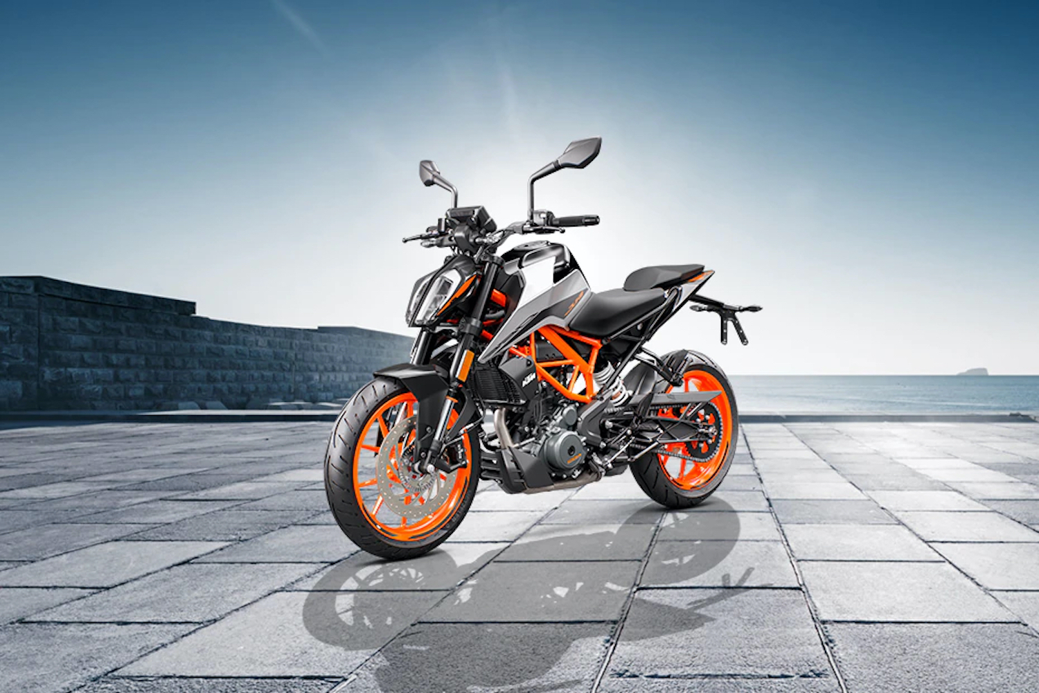 Front side profile of KTM 390 Duke on a brick road with a brick wall in the background.