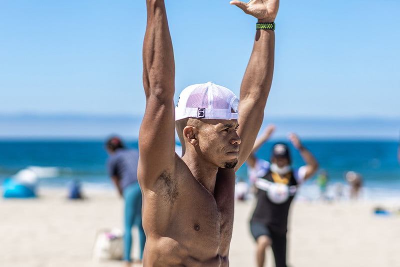 Fitness trainer and pro Kupah James demonstrating a simple back workout at the beach.