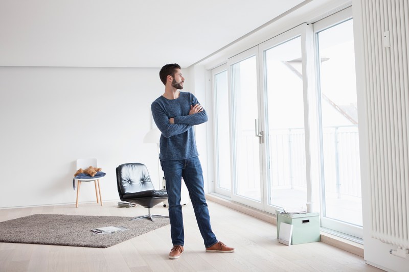 A man looking outside of his minimalist home.