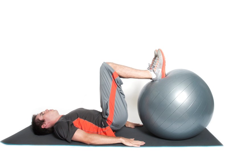 Man doing stability ball curls