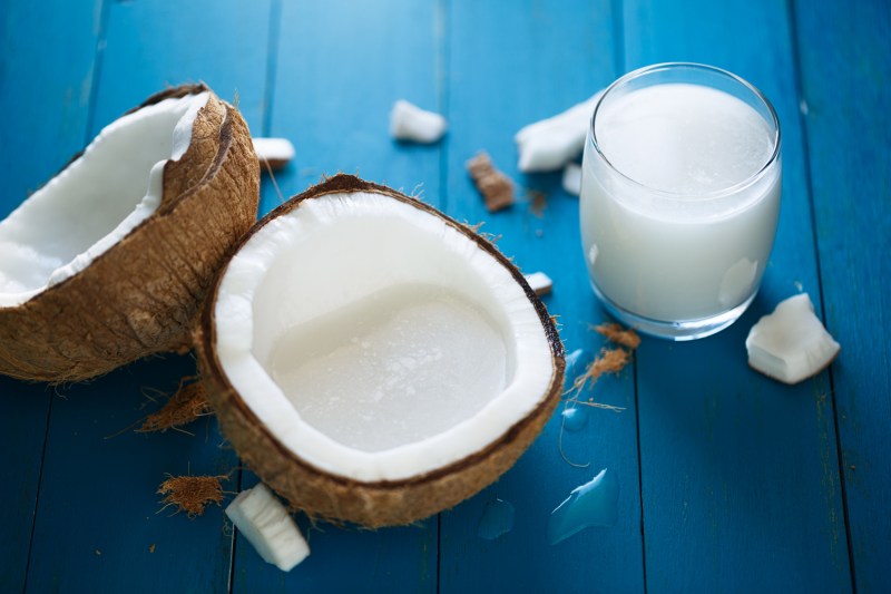 A coconut on a table with the milk