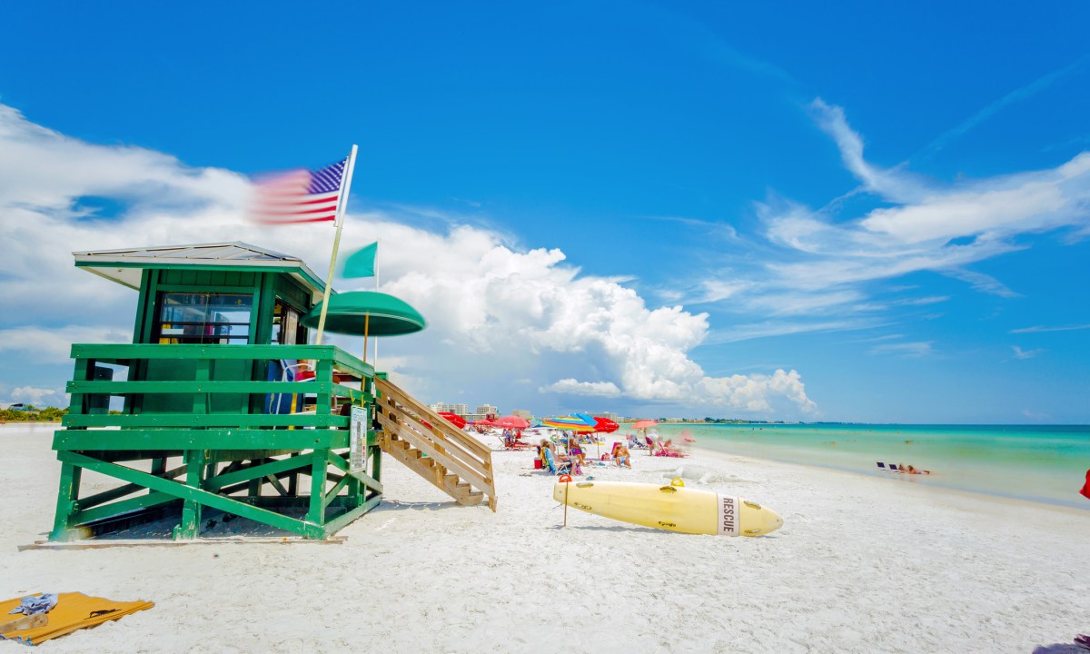 A lifeguard tower at Siesta Key beach in Sarasota, Florida with an American flag in the wind