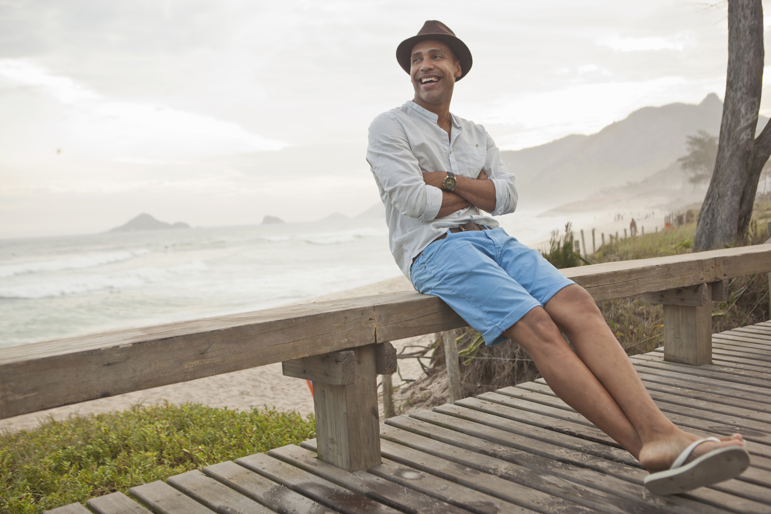 Man wearing a fedora hat and light blue chino shorts with flip-flops.