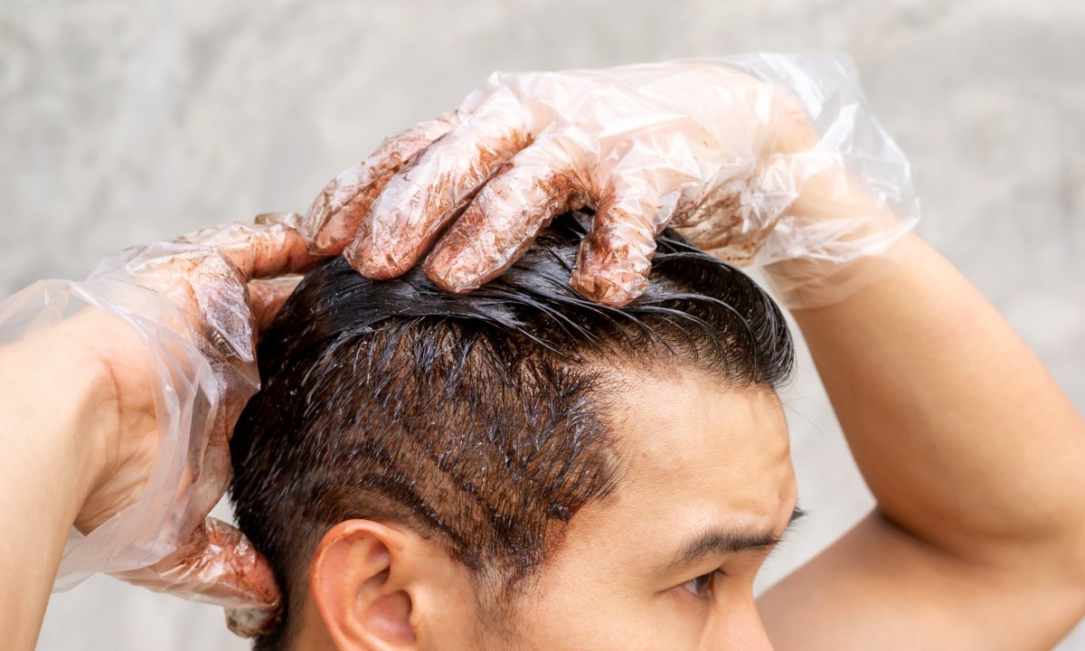 Many dyeing his hair with a gray background