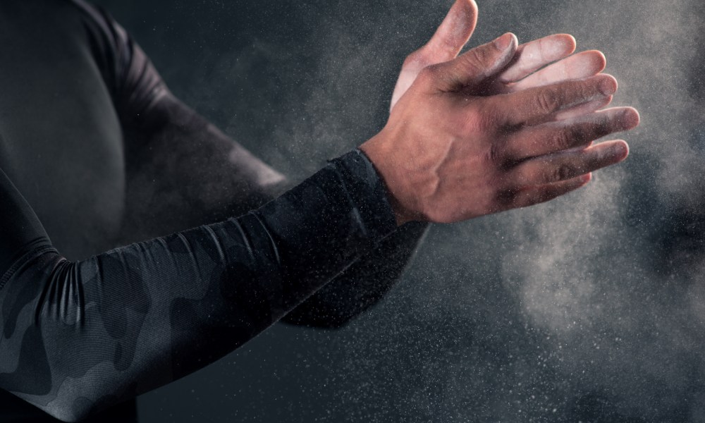 Man clapping hands with chalk powder before workout