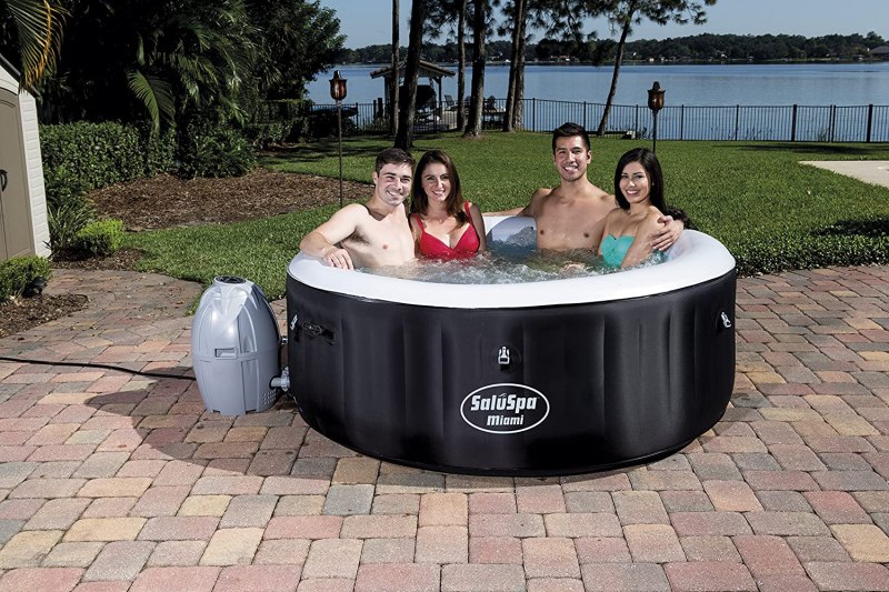 A group of people sit in a SaluSpa hot tub.