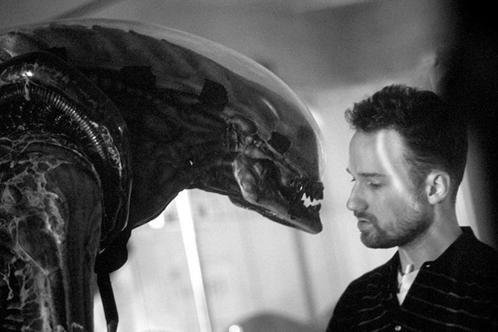 Black-and-white image of the creature from Alien staring at a man.
