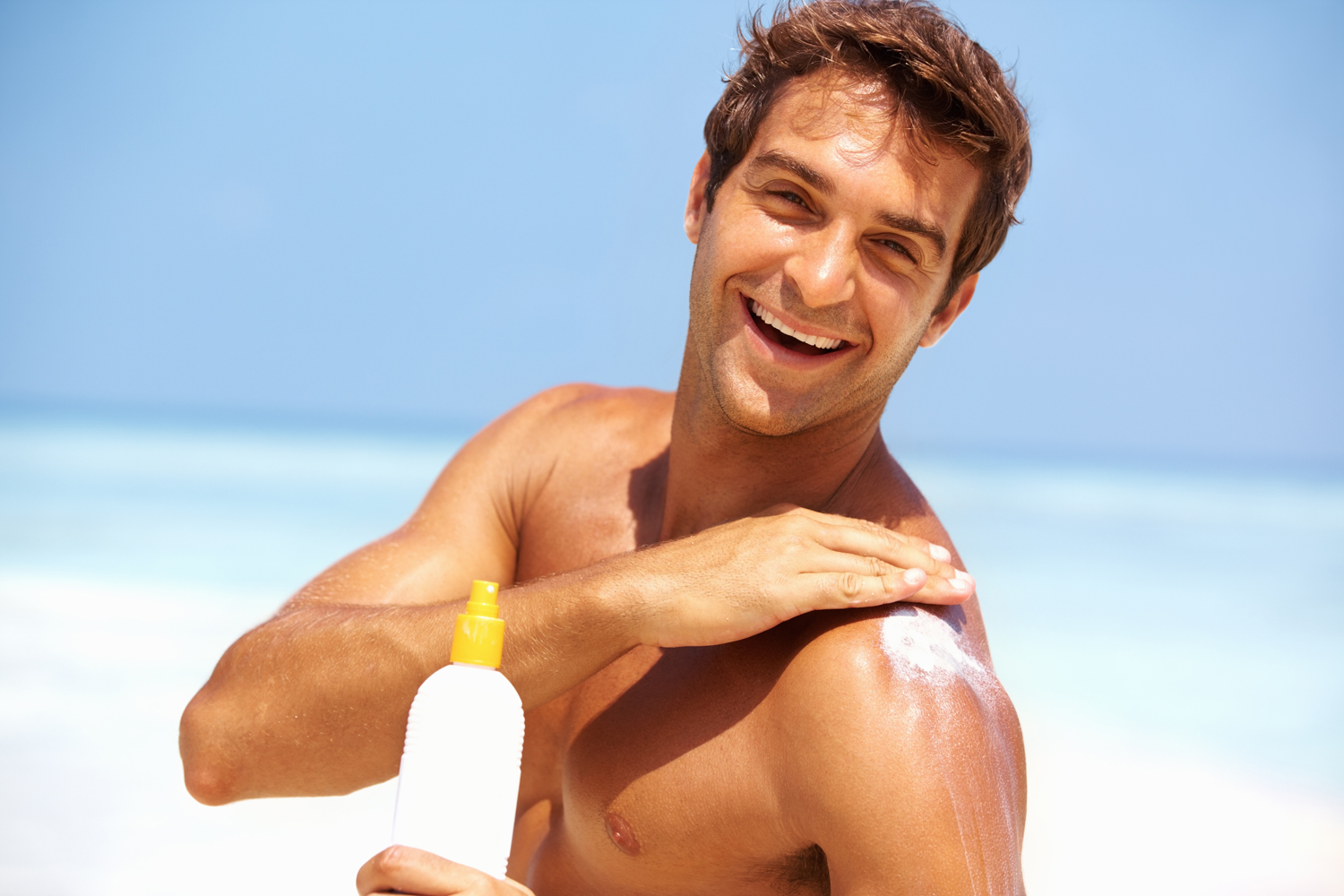 Man applying sunscreen on the beach