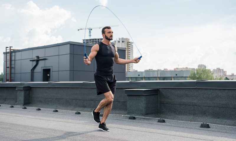 Man using a jump rope on a rooftop