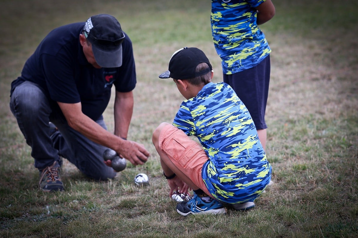 Man and kids with bocce balls