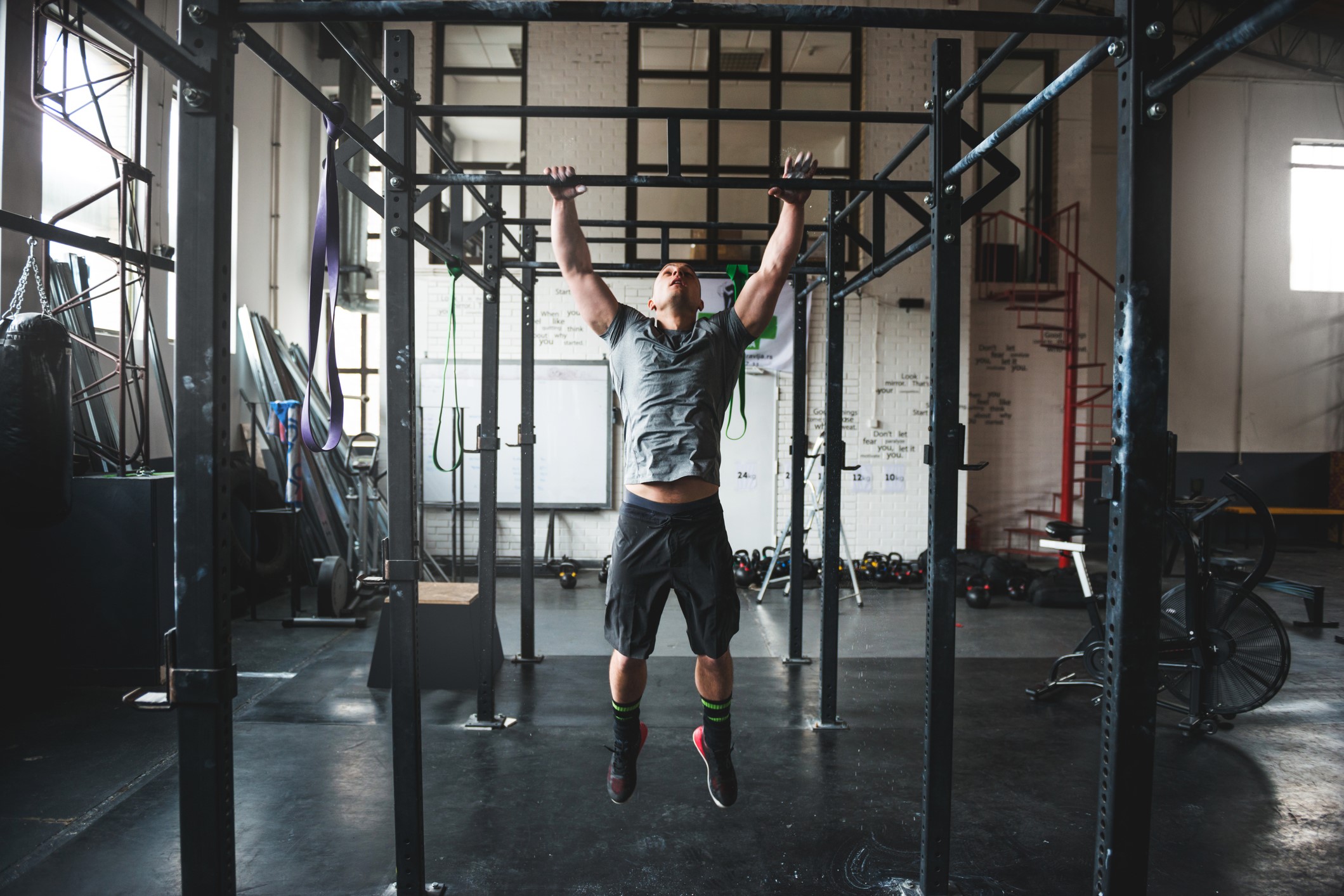 Man doing pull-ups in a gym