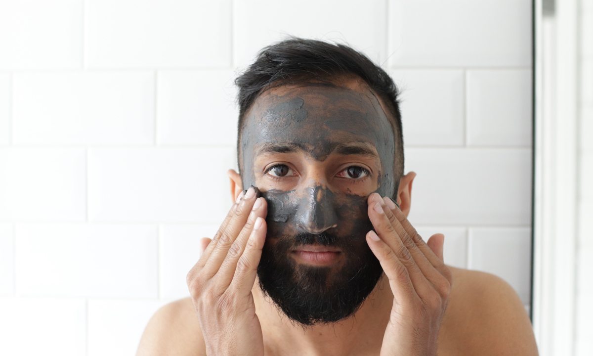 Man applying face mask in mirror