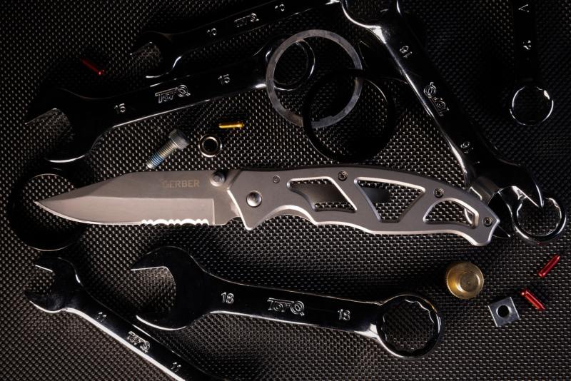 Picture of an EDC knife sitting on top of wrenches.