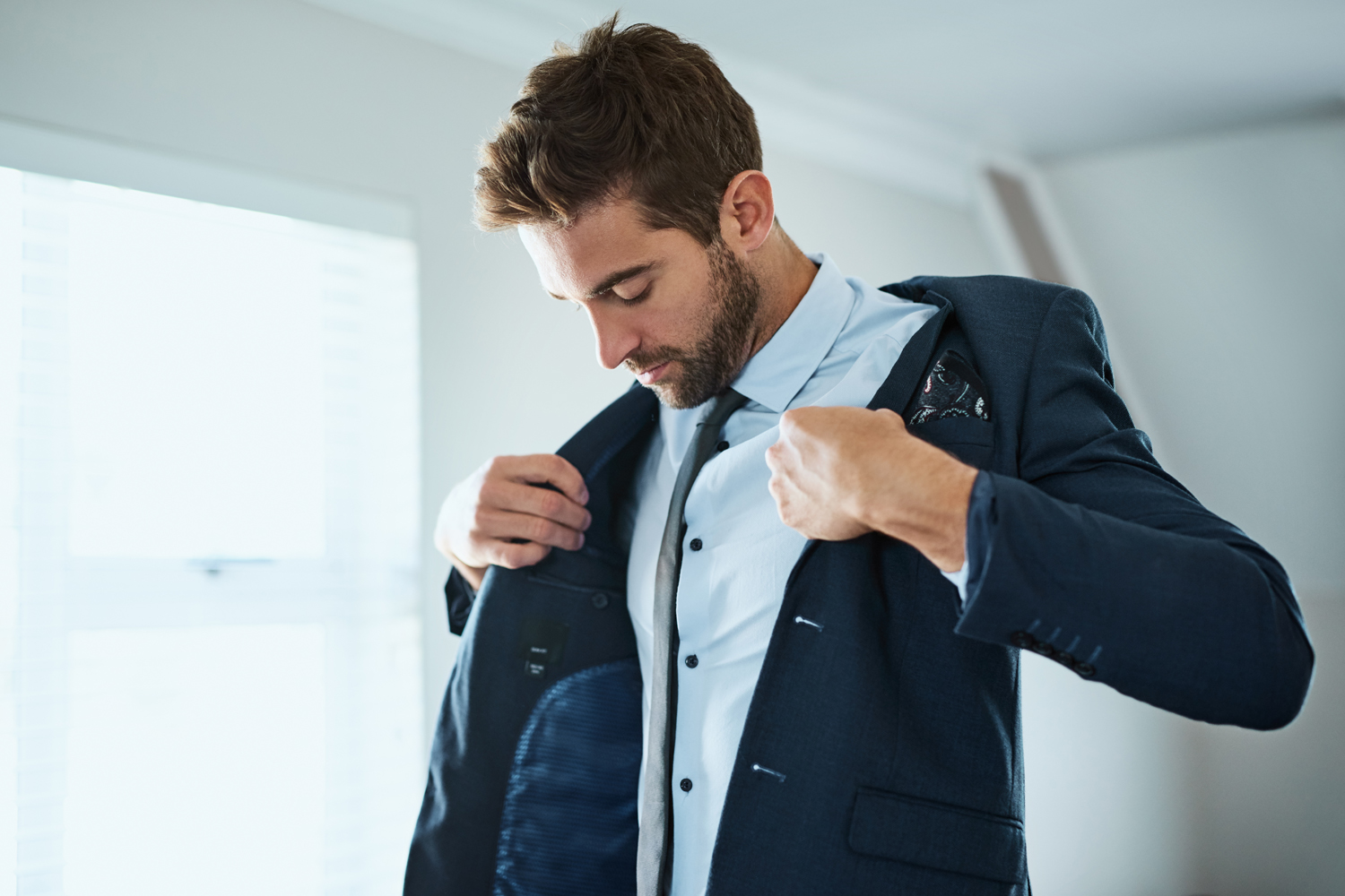 A man putting on his blazer