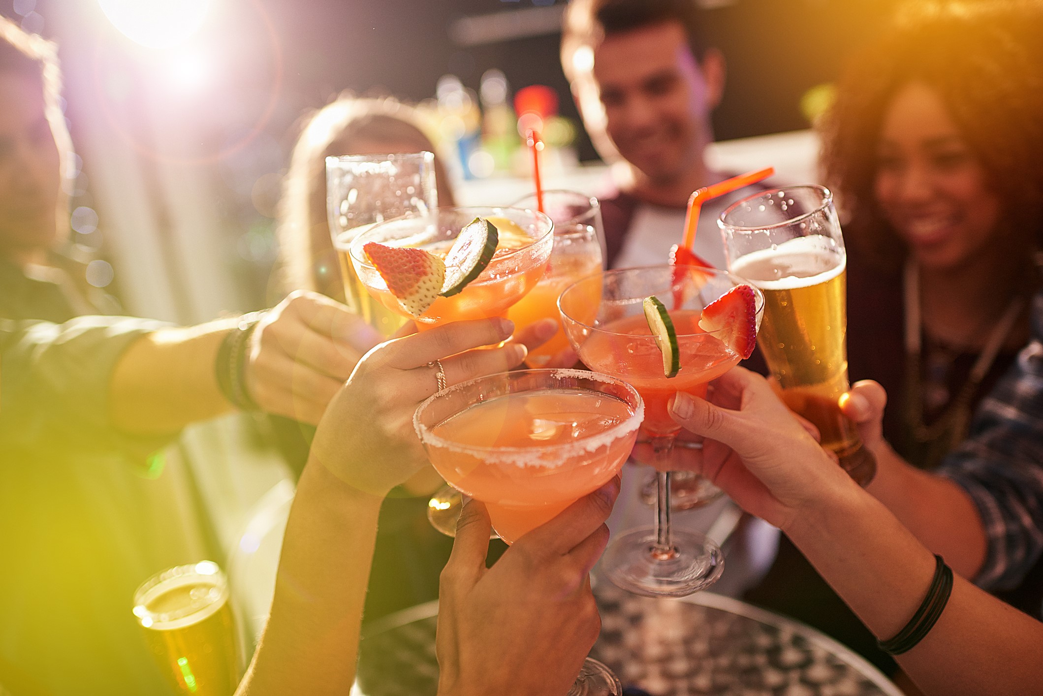 A group of people toasting with their drinks at a party.