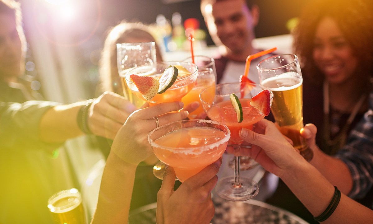 A group of people toasting with their drinks at a party.