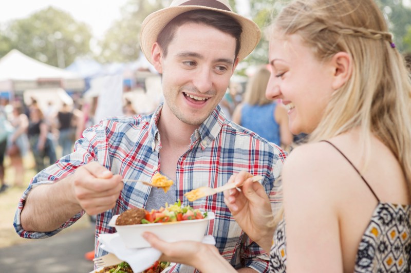 A couple sharing the lunch they bought at the food festival.
