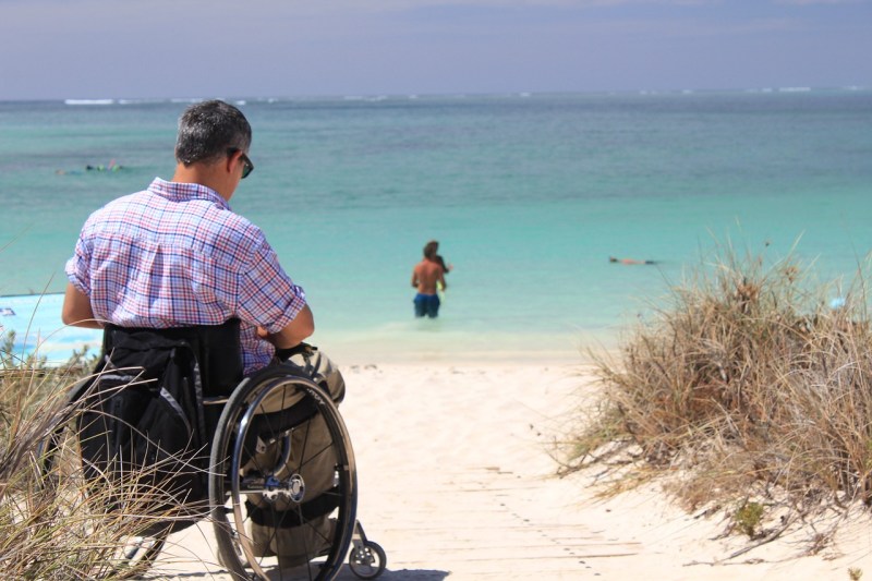 man in wheelchair by beach