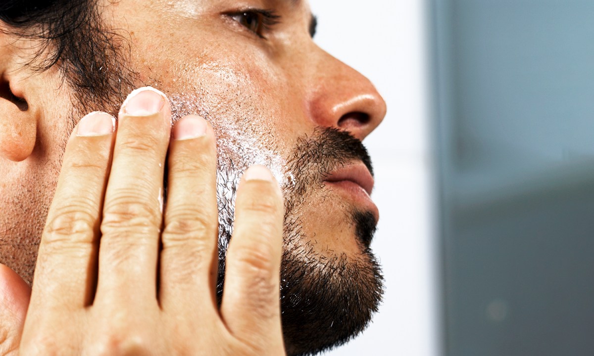 Man putting product on his face and beard.