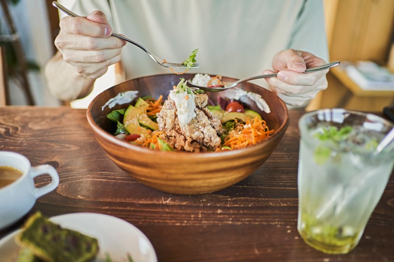 A man eating a hearty lunch from a bowl.