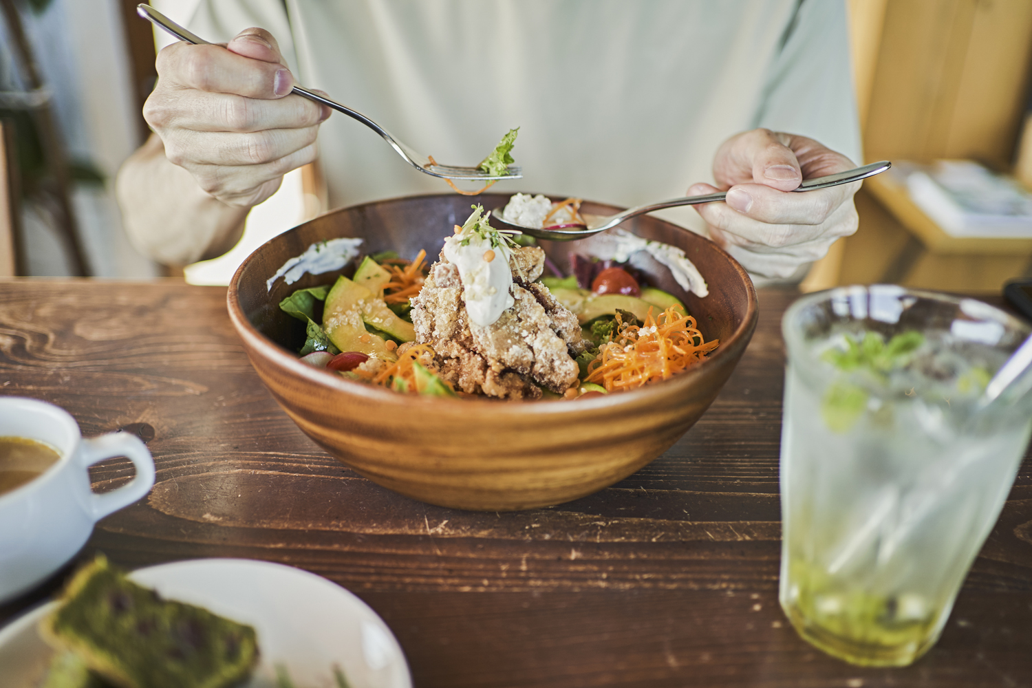 A man eating a hearty lunch from a bowl.