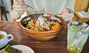 A man eating a hearty lunch from a bowl.