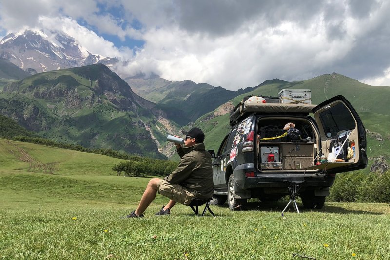 Man relaxing in the mountains with the best camping stool.