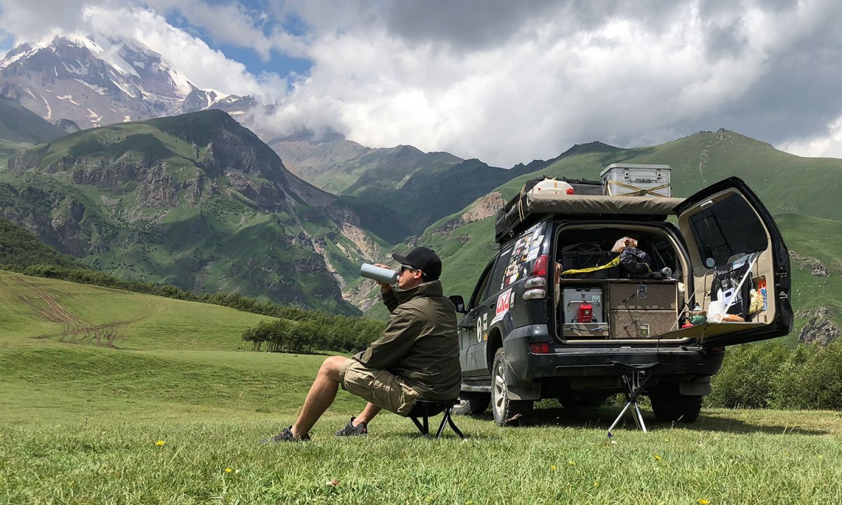 Man relaxing in the mountains with the best camping stool.