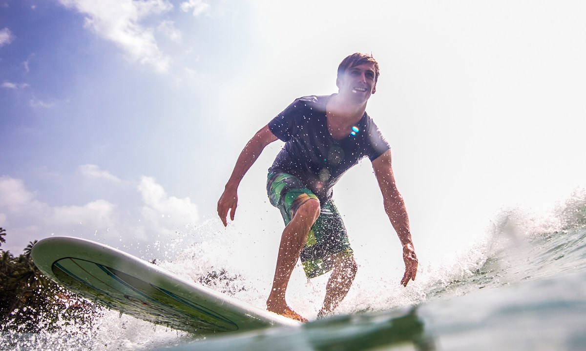 Water level view of man on surfboard.