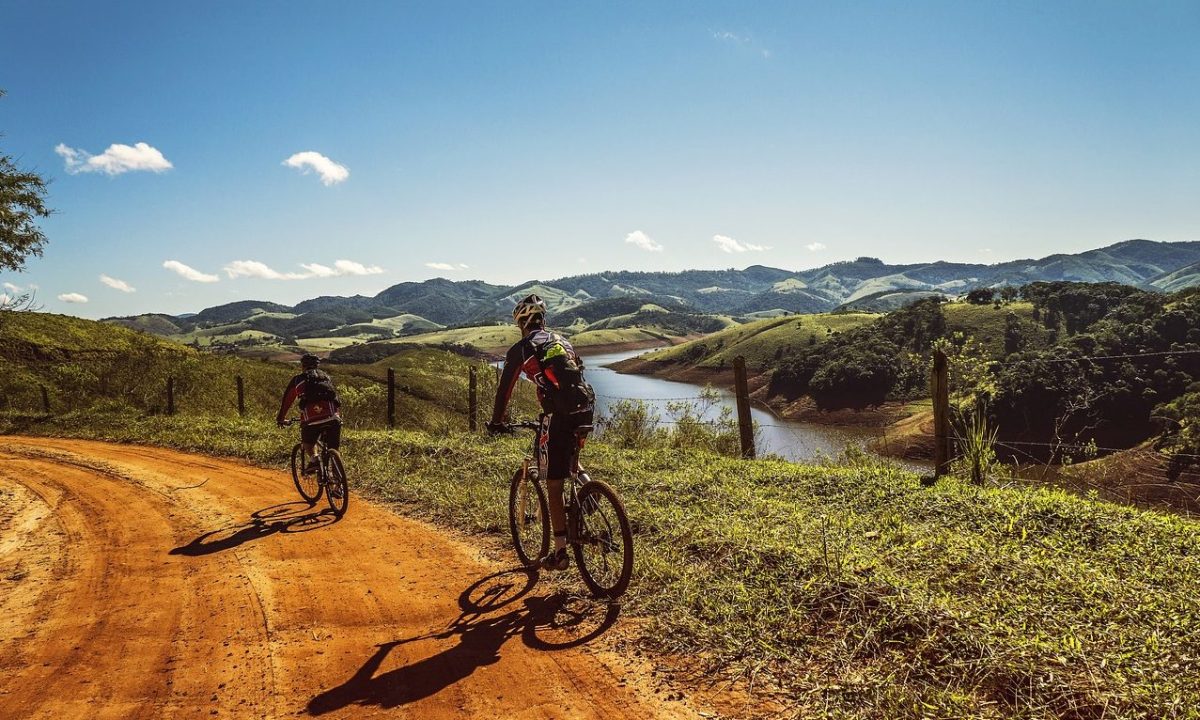 Two men cycling on a dirt road