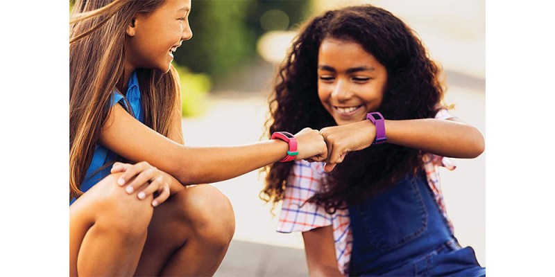 Two children wearing Fitbit Ace 2s and smiling.