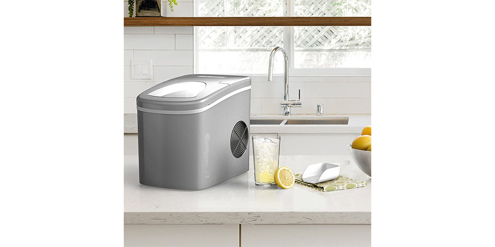 A kitchen environment depicting the Homelabs Chill Pill Countertop Ice Maker next to a sink.