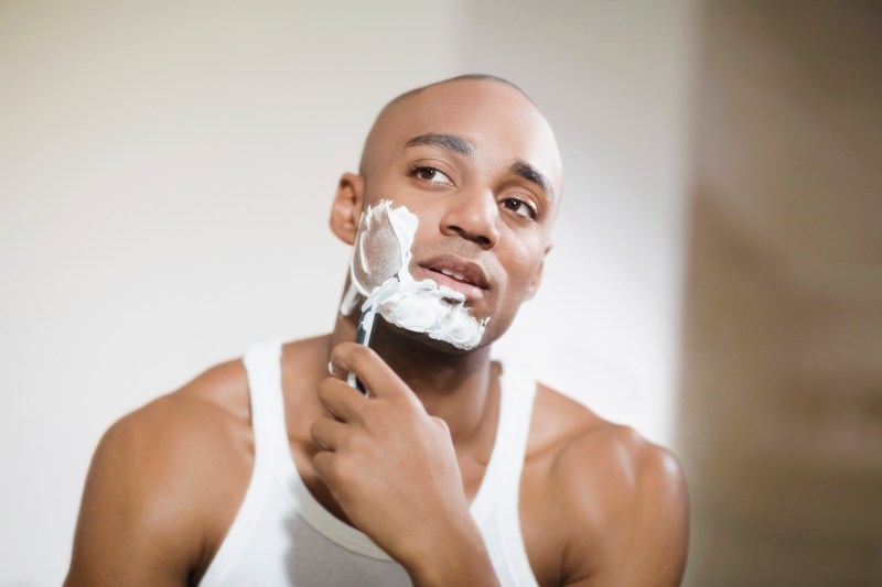 African man shaving face.