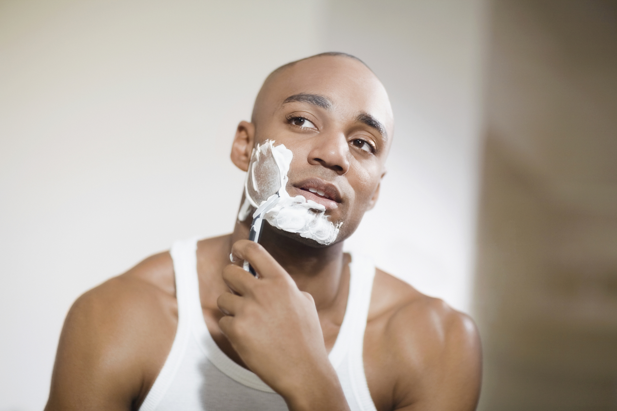 African man shaving face.