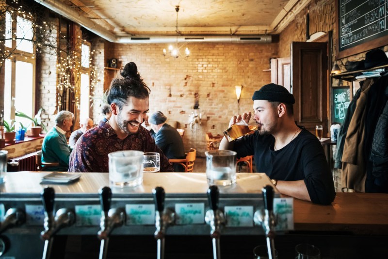 Two men enjoying drinks in a bar.