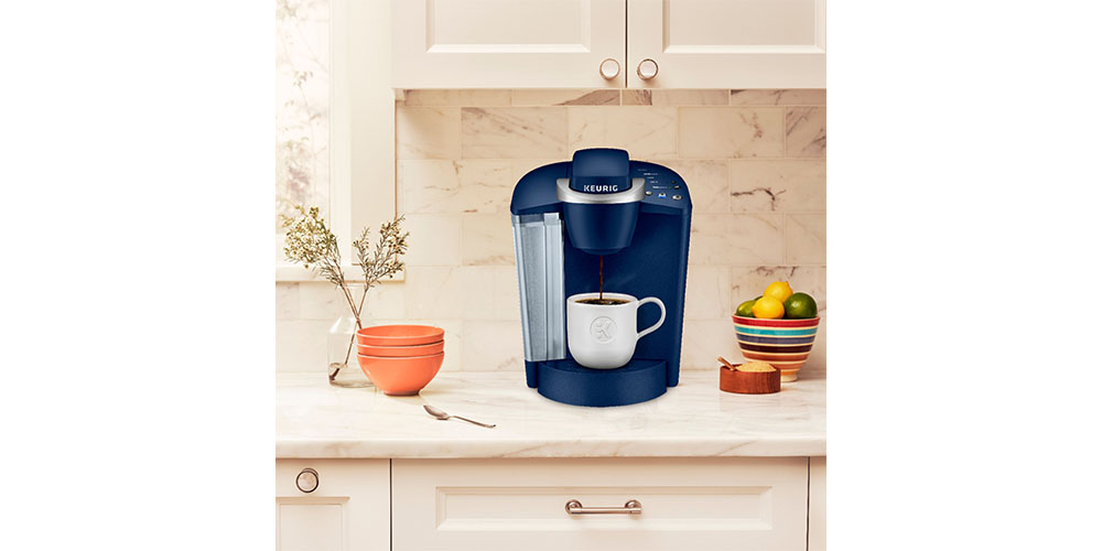 Keurig K-Classic Single Serve K-Cup Pod Coffee Maker placed on a kitchen countertop with plants nearby.
