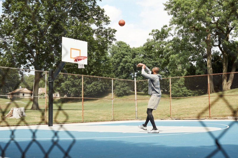A man playing basketball at an outdoor court.
