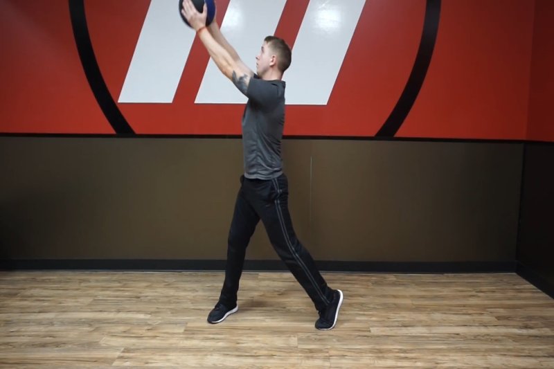 An athlete doing medicine ball chops.