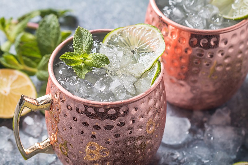 Moscow mule drinks in ceramic mugs garnished with lime and mint.