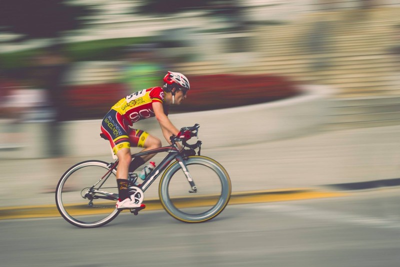 Person riding a bike fast with blurred background.
