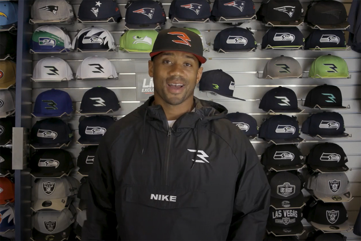 Russell Wilson wearing a hat from his new line with Lids.