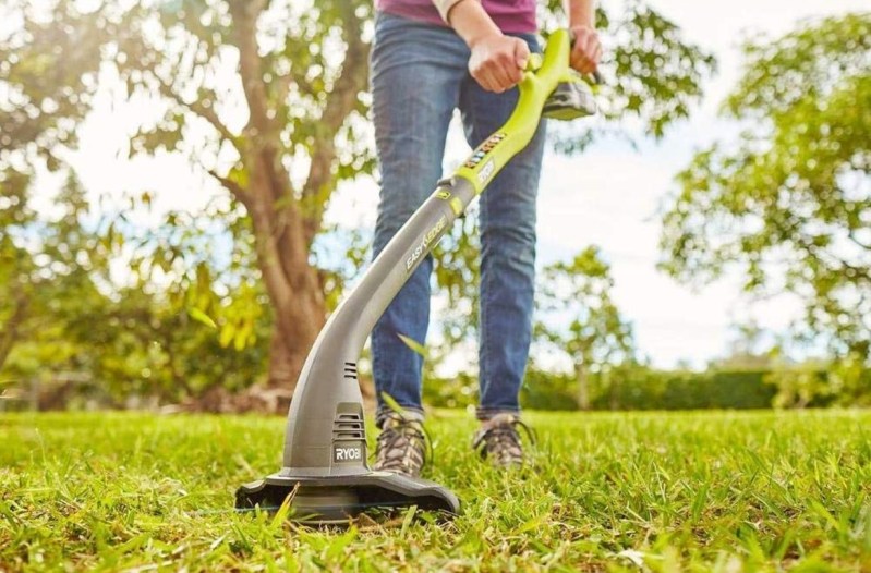 Using a Ryobi String Trimmer on a lawn.