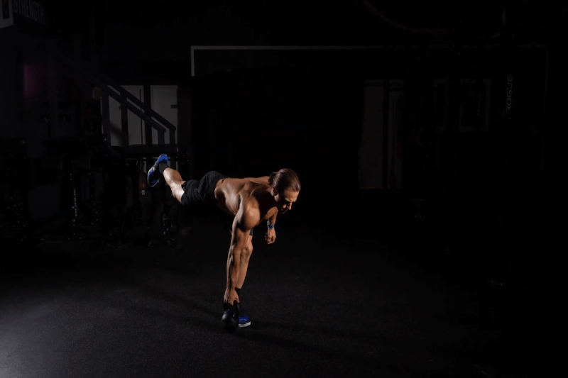 Marcus Filly performing a single-leg deadlift with a kettlebell.