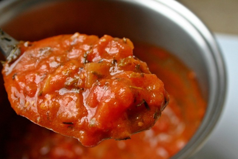 Spoonful of tomato sauce and herbs.