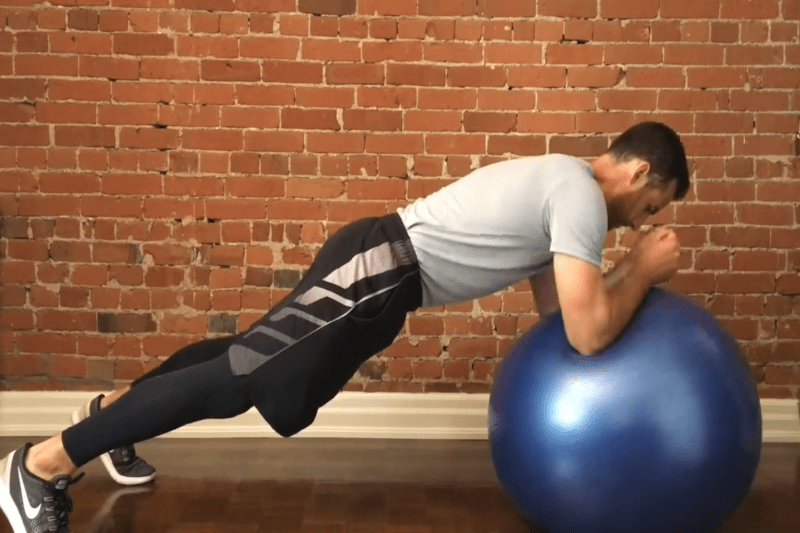 A man performing the stability ball alphabets.